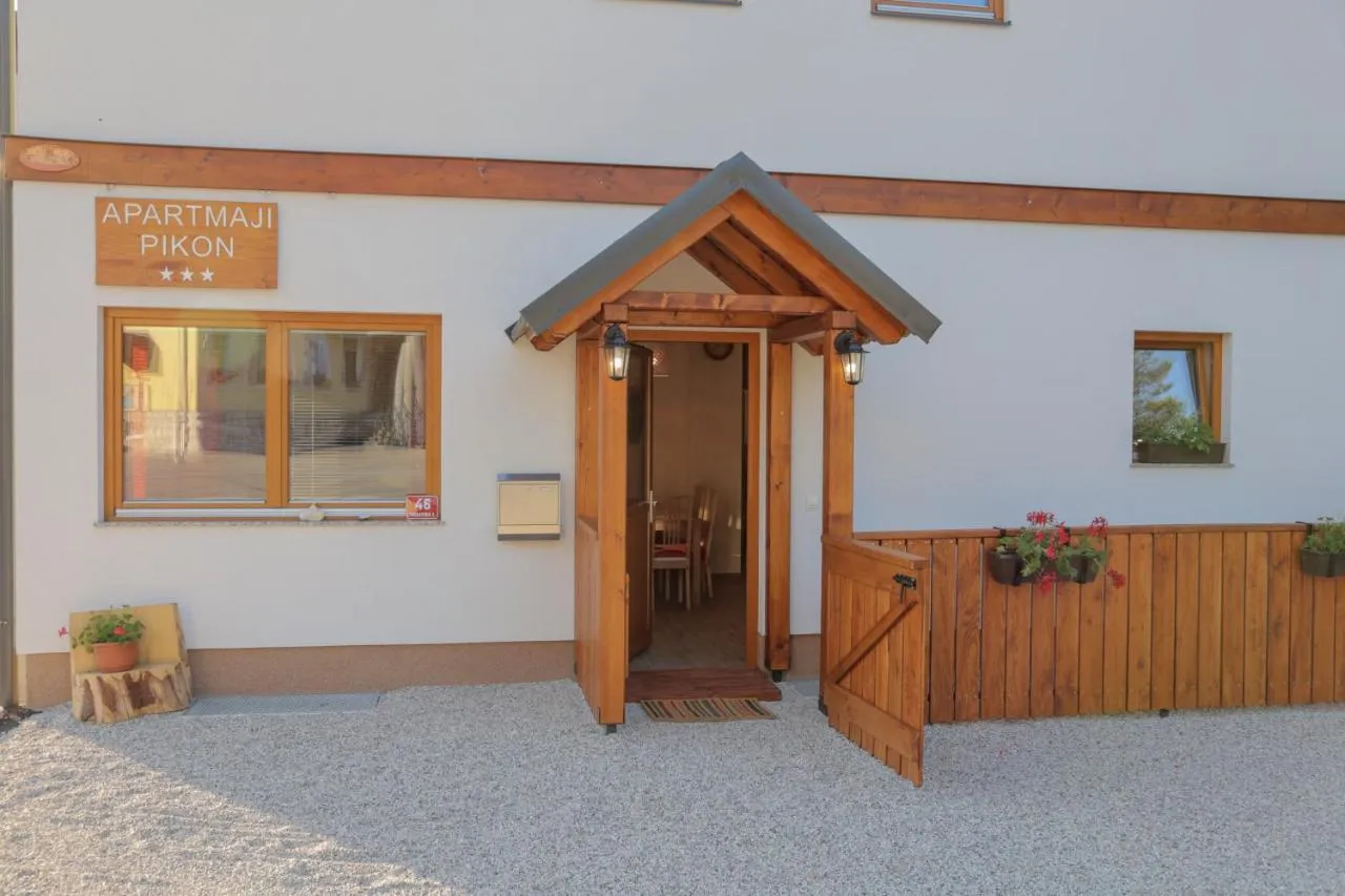 Lesen vhod v hišo z napisom Apartmaji Pikon