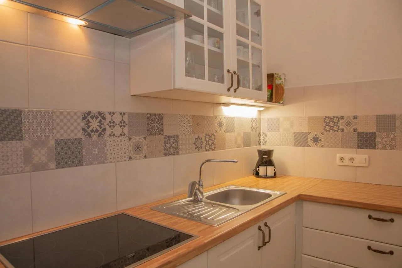 Kuhinja s štedilnikom, kavnim aparatom in lesenim pultom